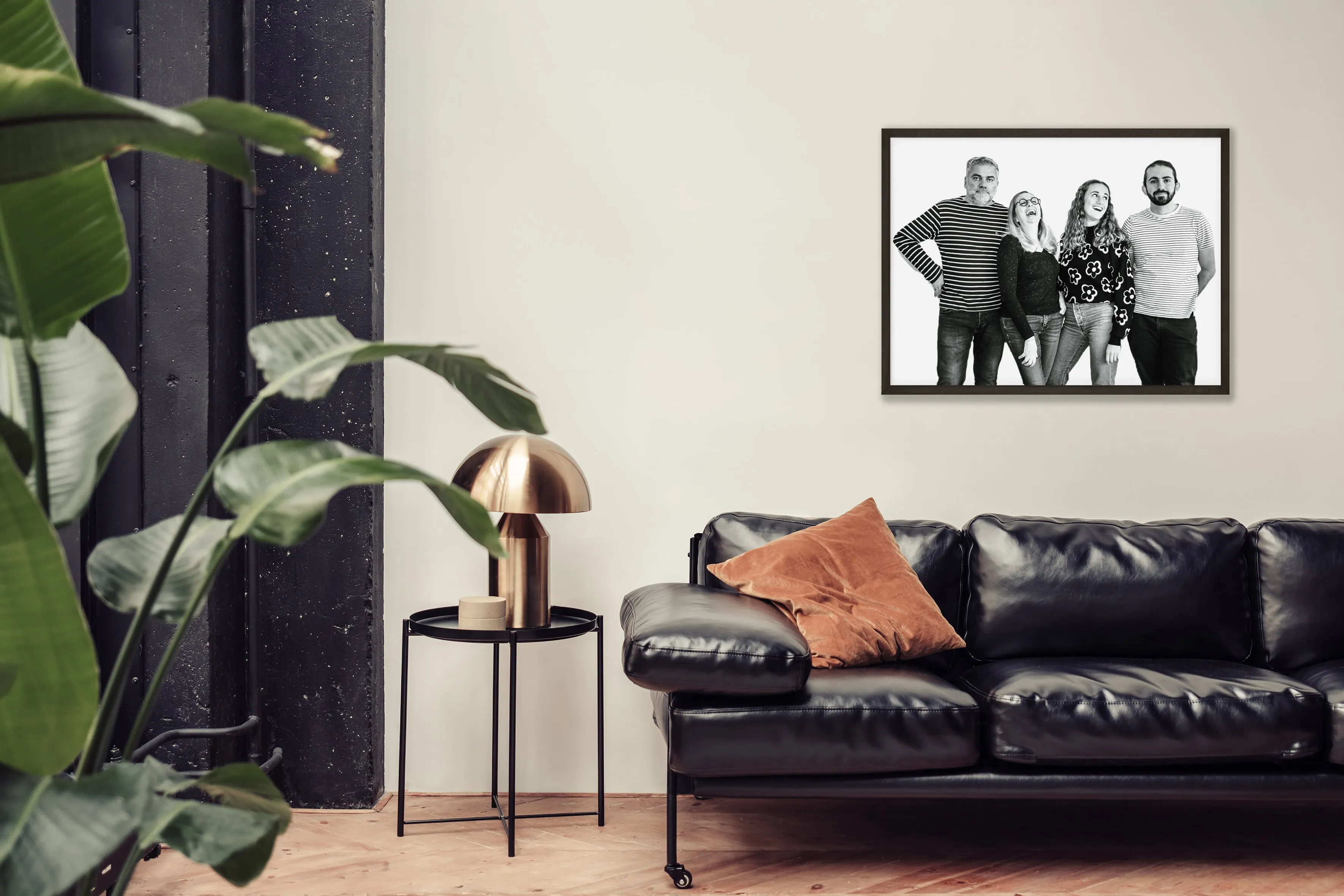 Candid family portrait of four adults laughing and interacting against a white studio backdrop