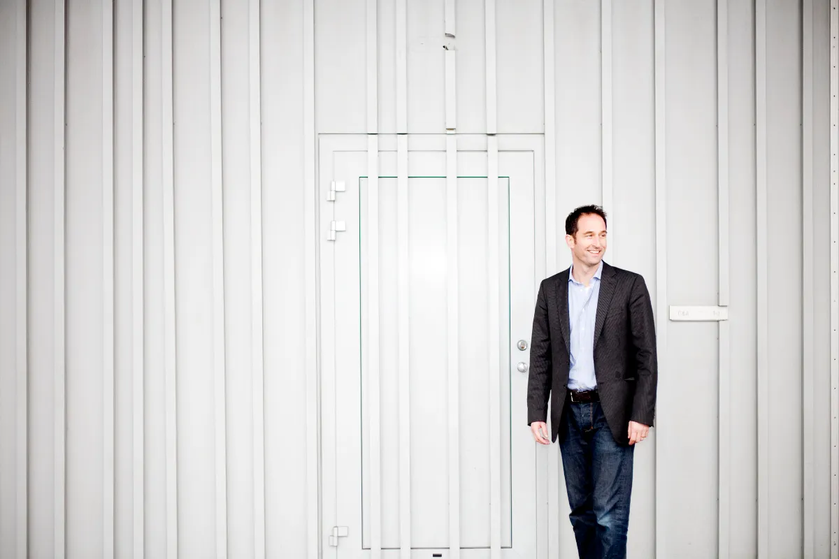 Business portrait of a man in a blue suit standing confidently in a modern corporate setting