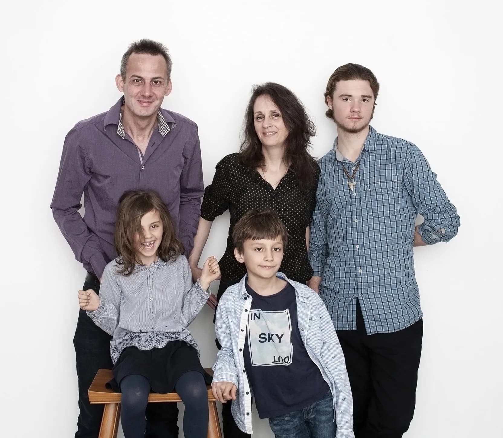 Family portrait wall art of four individual B&W portraits displayed in an elegant living room